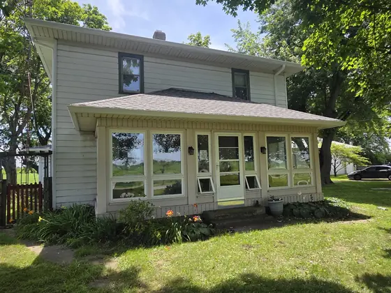 White house with front porch and freshly installed gutters