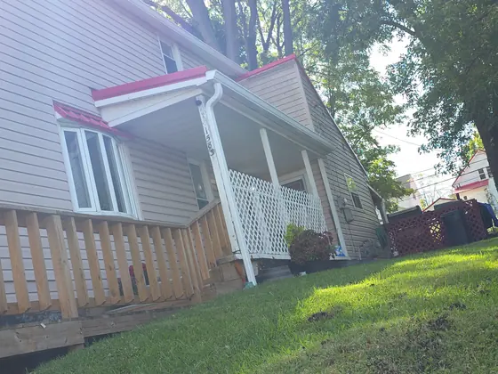 White sided house with new gutters along the porch roofline