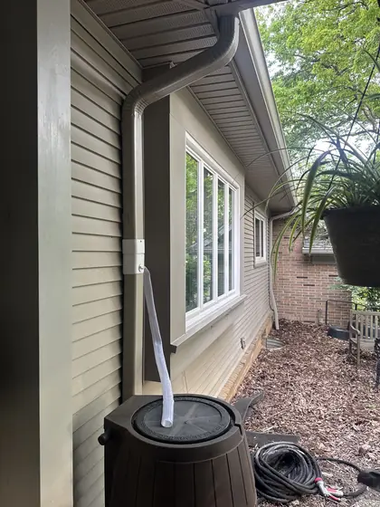 New downspout beside a picture window and patio